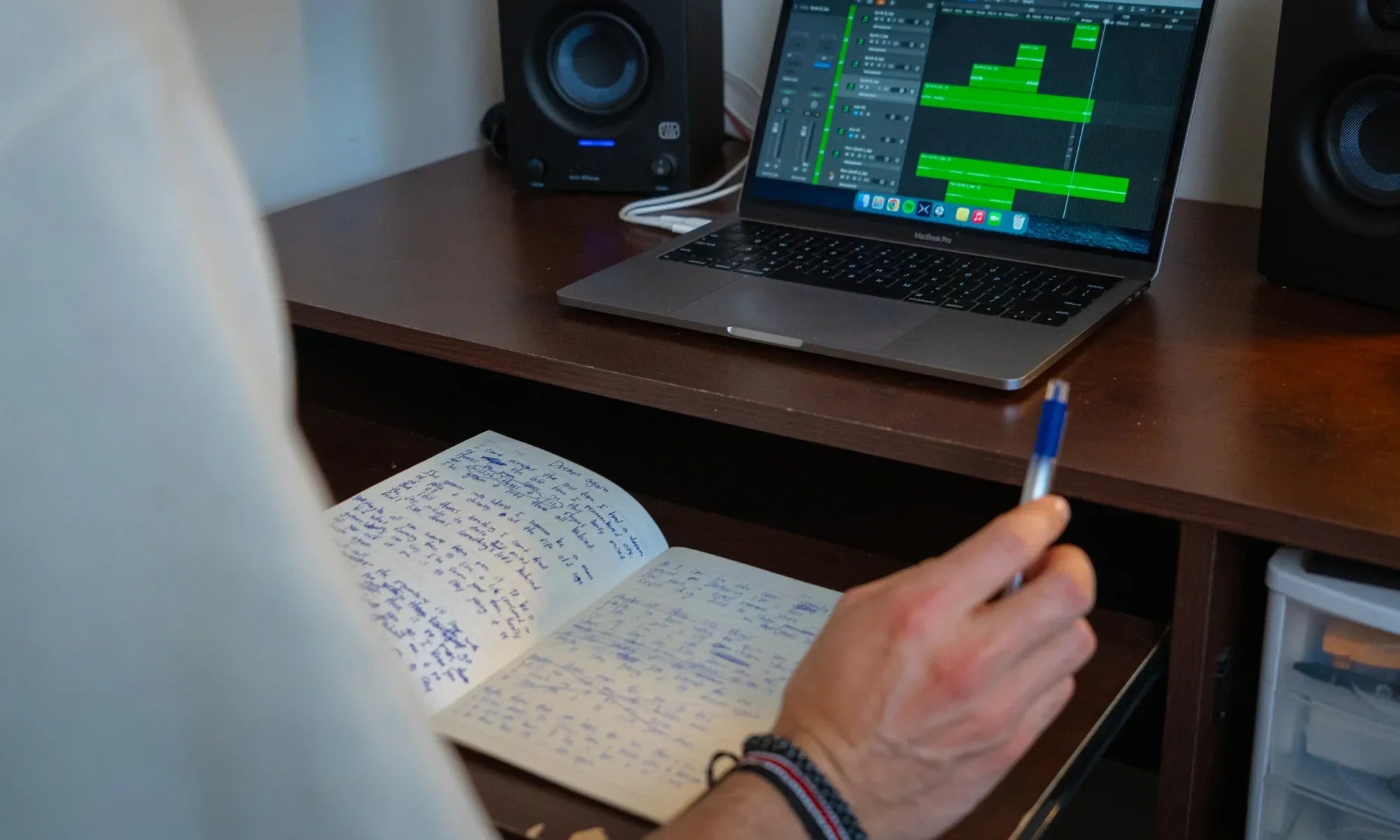 Songwriter sitting at desk with a notebook
